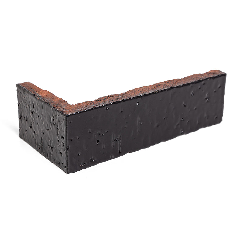 A 2x8 glazed brick corner in Abyss, the glazed face wrapping the return with the red clay body on the cut edges
