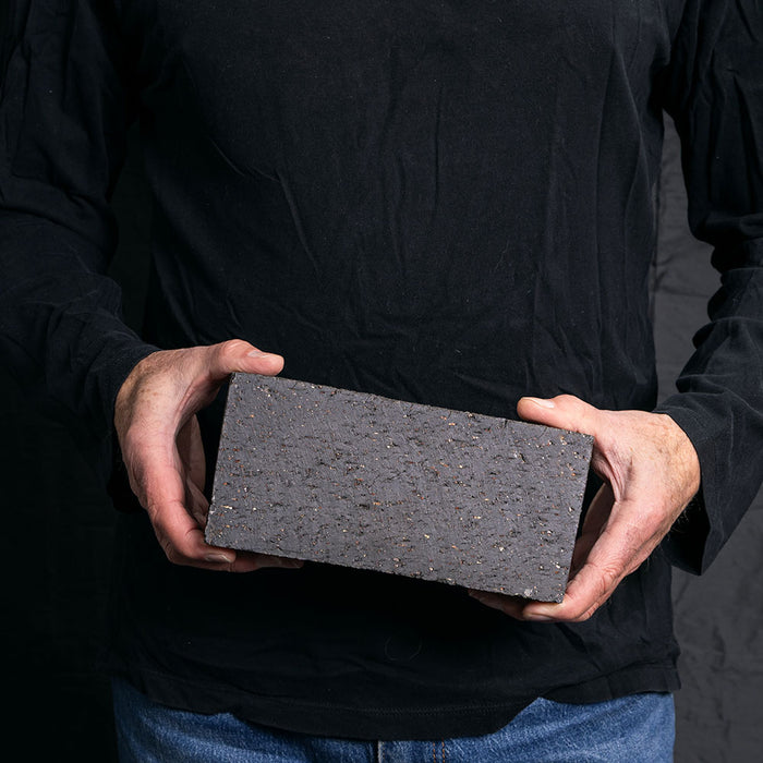A Catalina brick paver in Charcoal held in a hand
