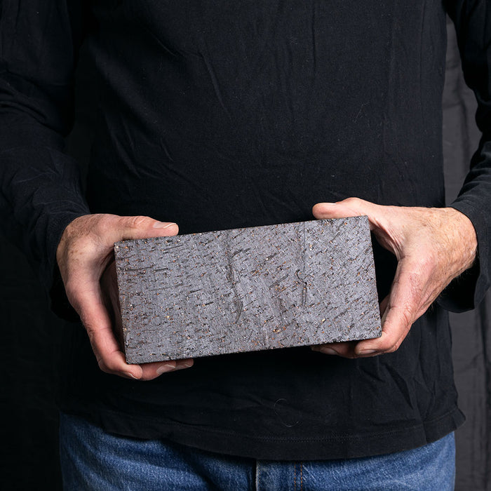 A Catalina brick paver in Dark Ironspot held in a hand