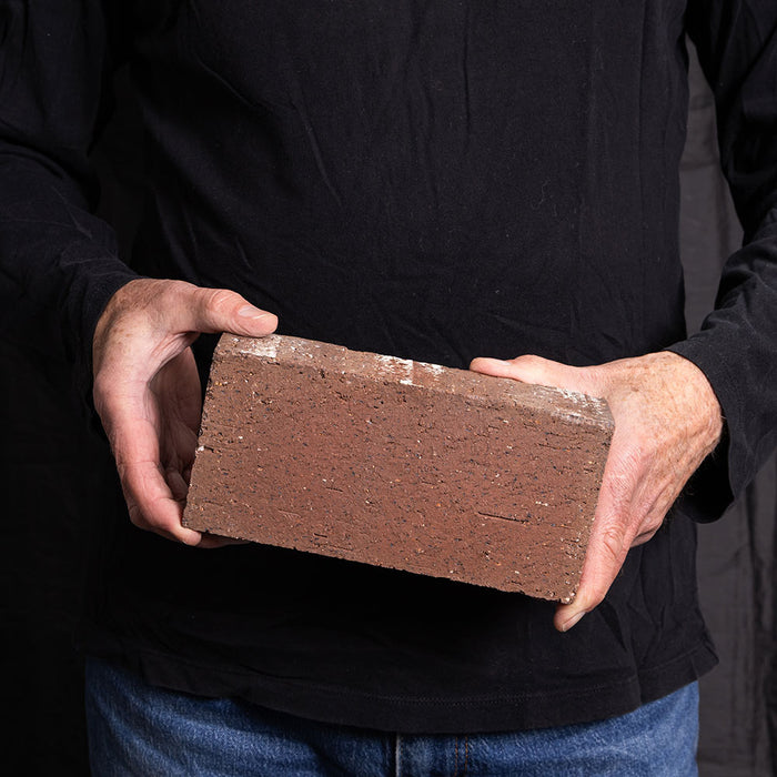 A Catalina brick paver in Light Ironspot held in a hand
