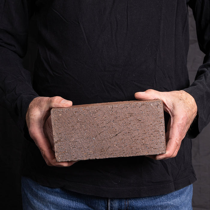 A Catalina brick paver in Medium Ironspot held in a hand