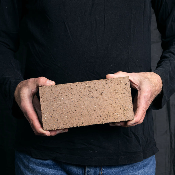 A Catalina brick paver in Pueblo Flashed held in a hand