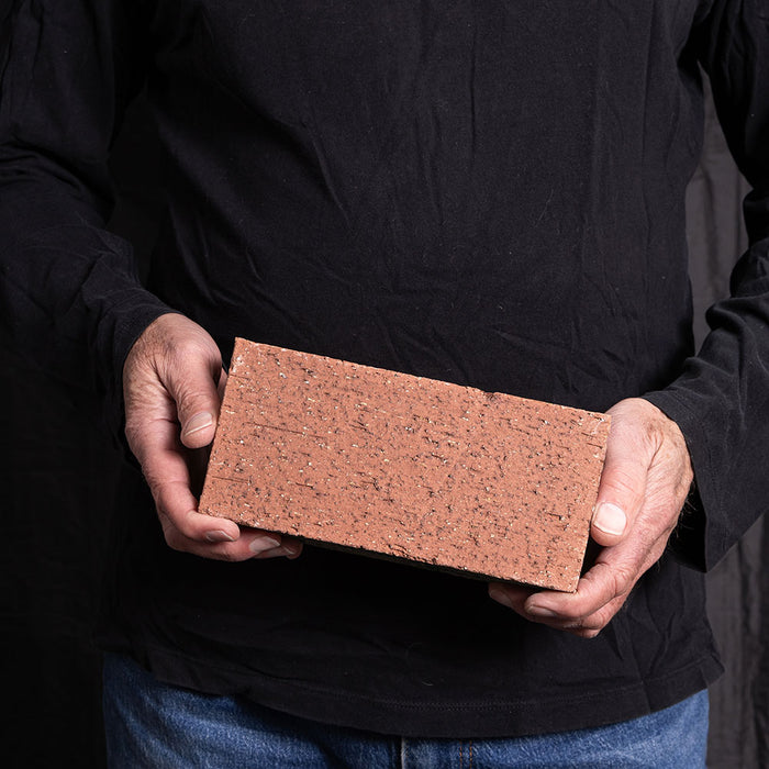 A Catalina brick paver in Rose Tan held in a hand