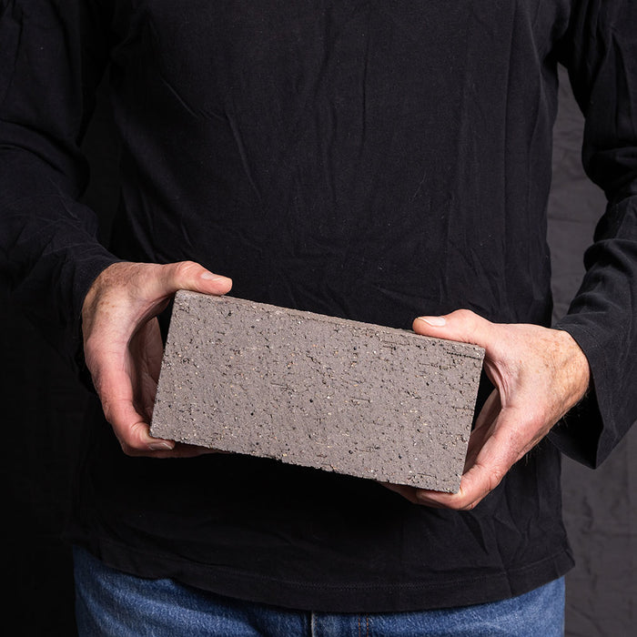 A Catalina brick paver in Sterling Grey held in a hand