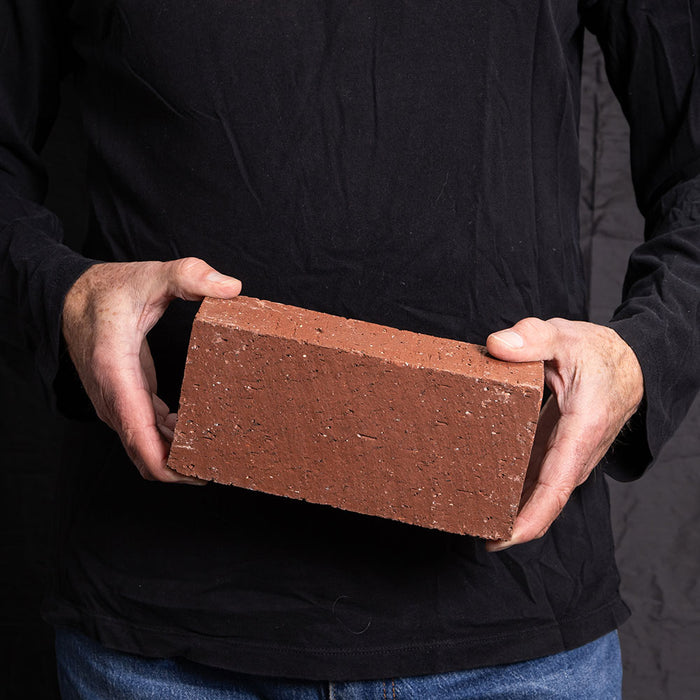 A Catalina brick paver in Sunset Red held in a hand