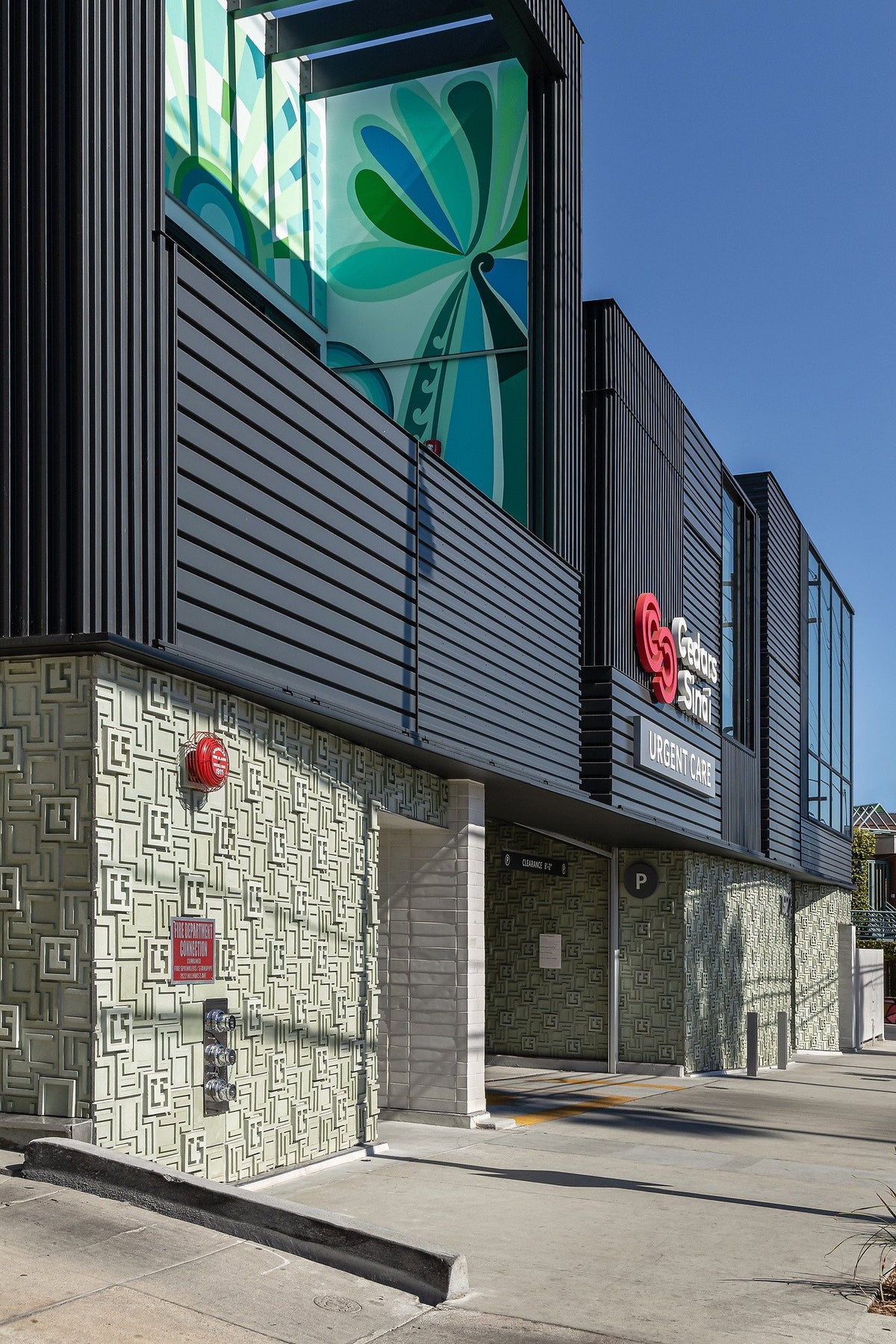 Green cladding below the dark upper floor