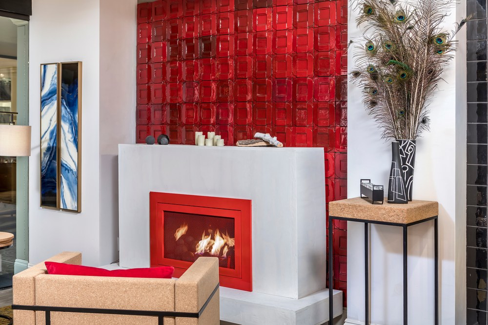 Ceramic 3D Impressions panels covering a chimney wall behind a fireplace, in a gloss red glaze