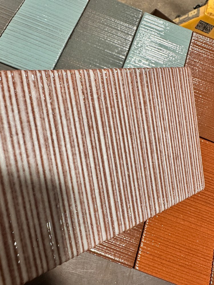 A Corduroy tile close up, glaze pooled dark in the grooves and pulled thin over the ridges