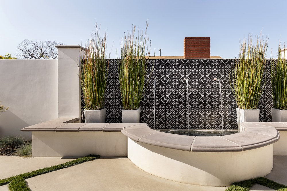 A handpainted 6x6 design facing a water feature in El Segundo, capped with Roman wall cap