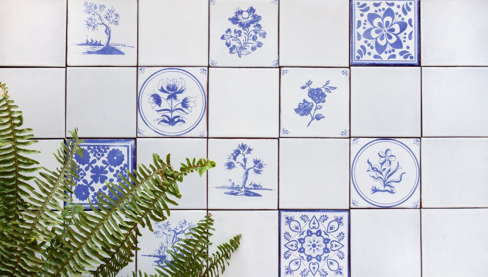 Assorted Peninsula decos scattered sparsely through a plain field, trees, medallions and flowers, behind a fern