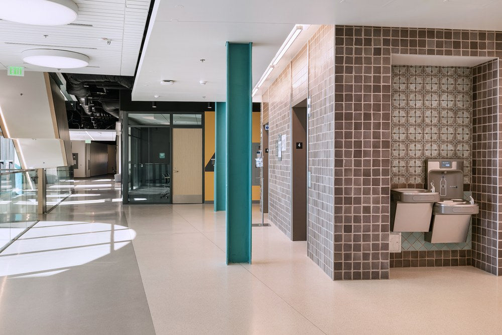 Scirocco decos run as a panel above a drinking fountain alcove in a college corridor, at Glendale City College