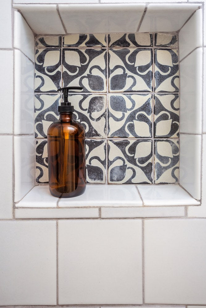 A deco panel set into a shower niche, framed by a plain white field
