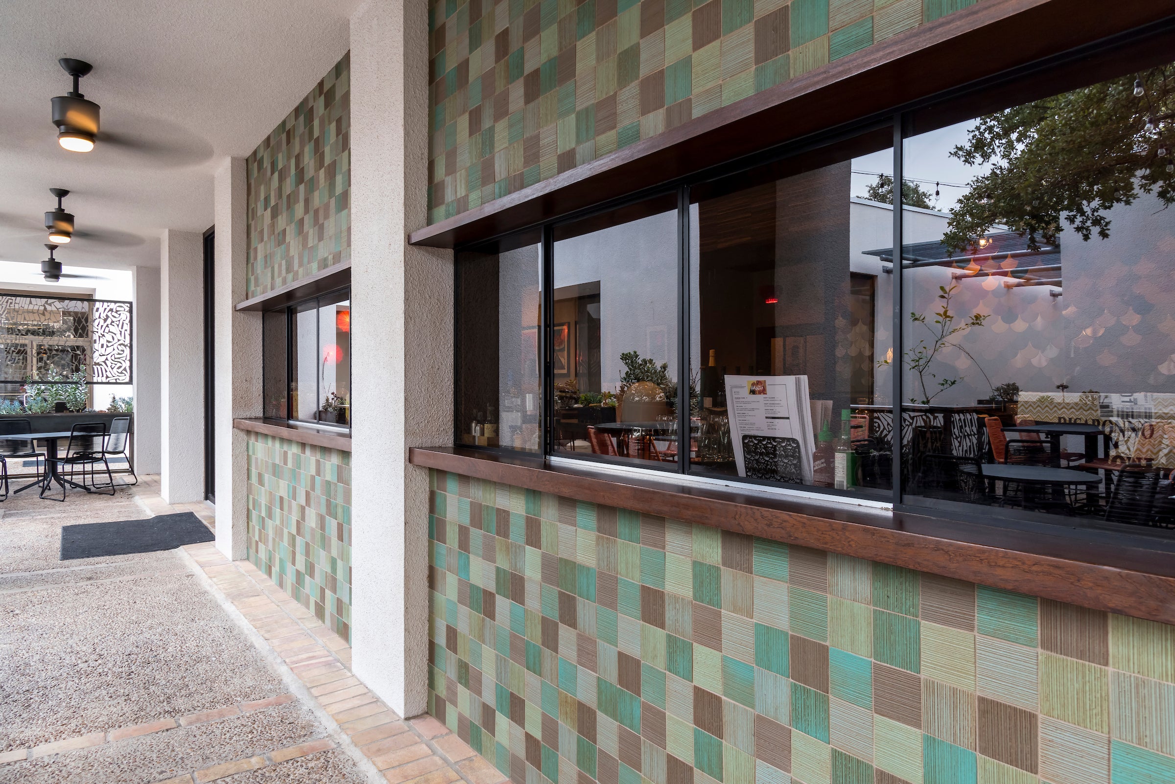 The same building along its walkway, the tile wrapping from the covered patio to the open one