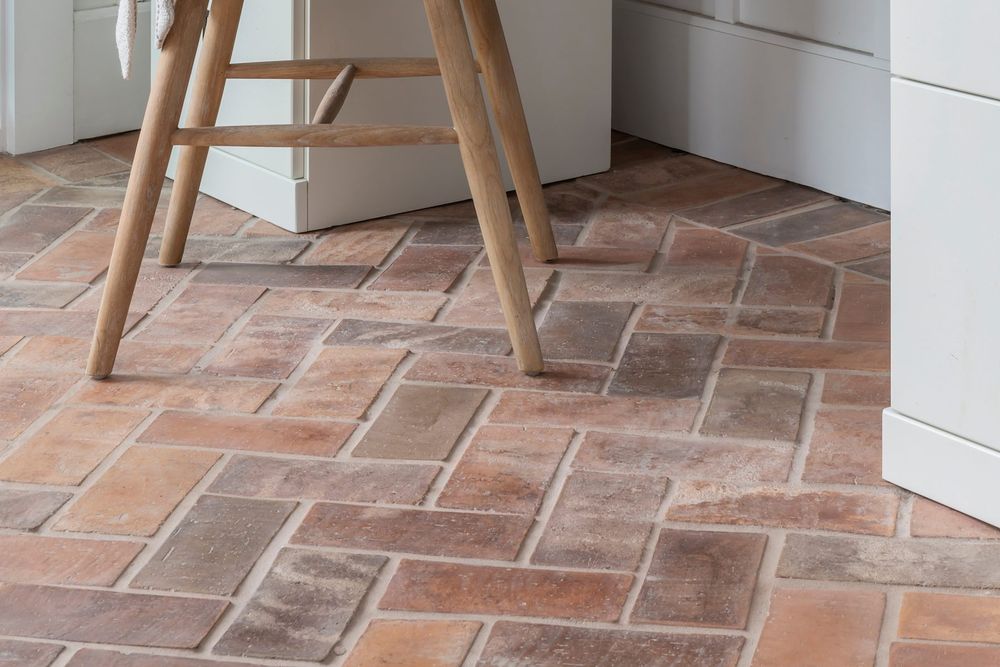 Swept Brick in 4 by 8 Normandy Cream herringbone floor beneath a desk and oak chair