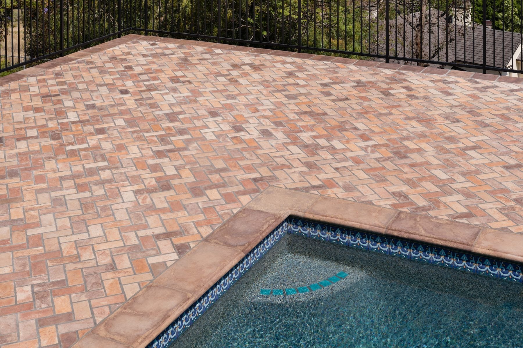 Swept Brick in Creme Fraiche laid herringbone on a Tustin pool deck, hills beyond