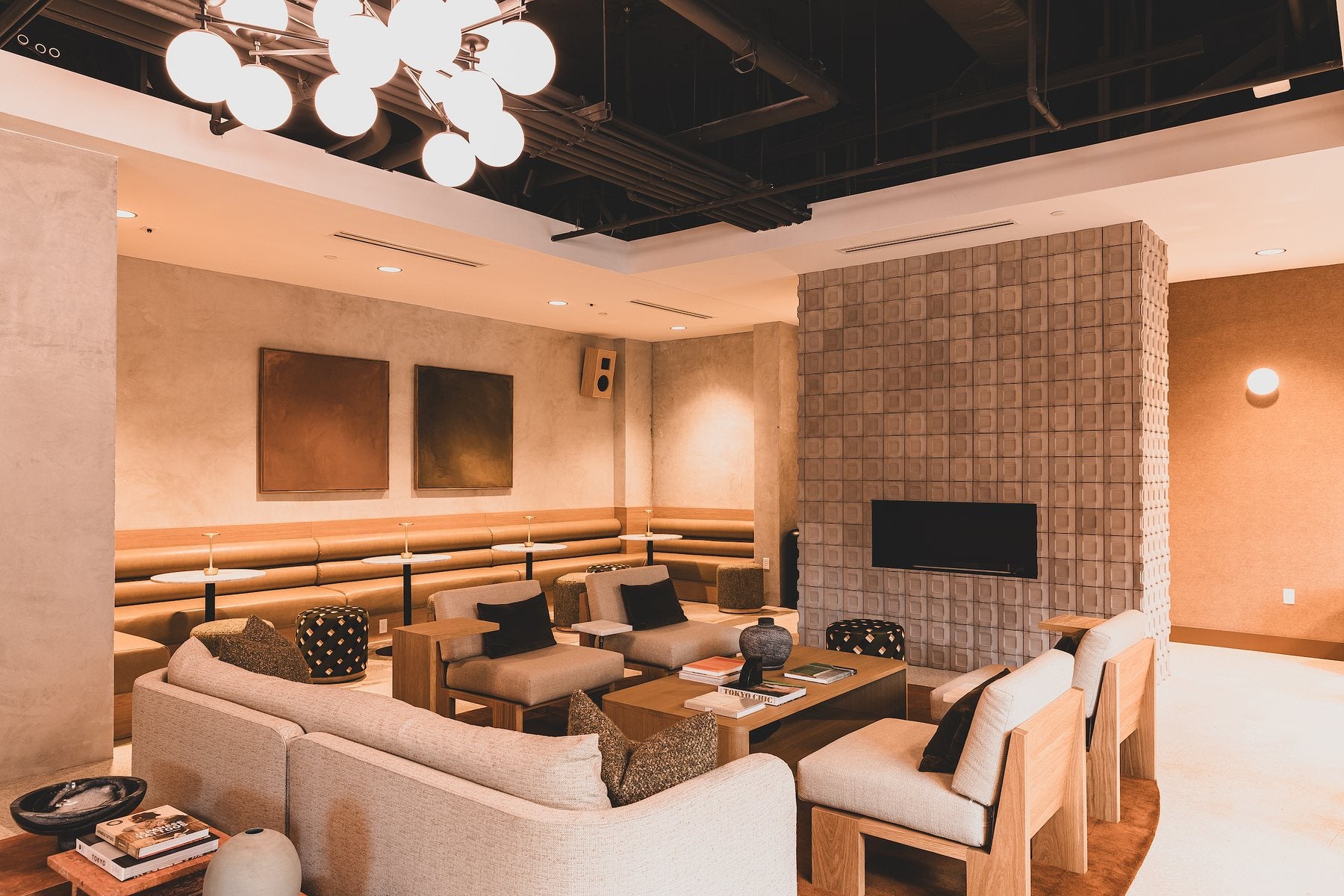 A full height Buckle 6x6 concrete wall in Natural Gray in a hotel lounge, with banquette seating in front of it