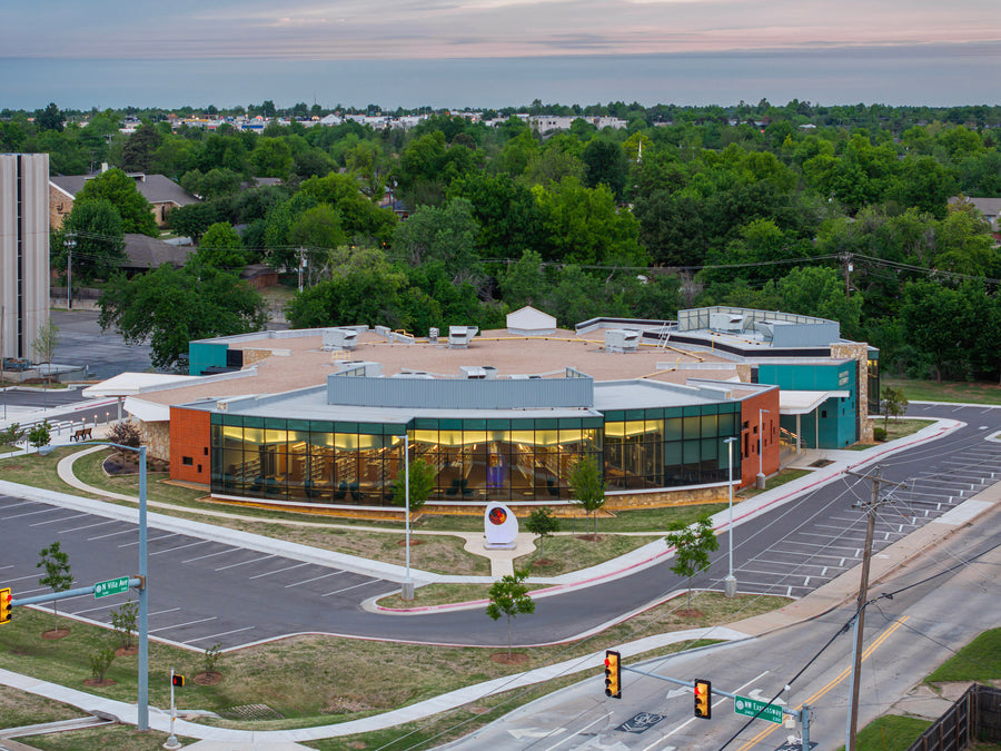 Belle Isle Library at dusk, seen from above, its glazed brick volumes reading against the stone and the glass