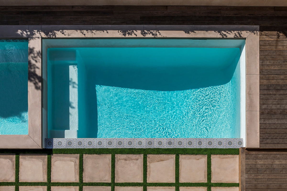 Pool edge framed by turf and pavers