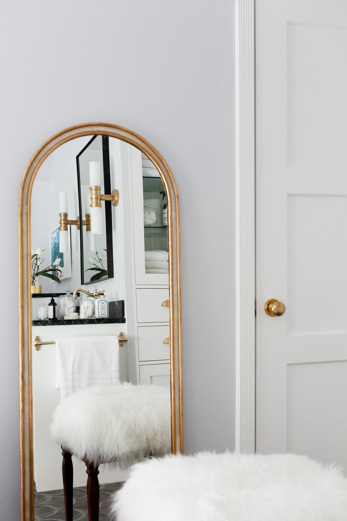 Arched mirror and dark tile floor