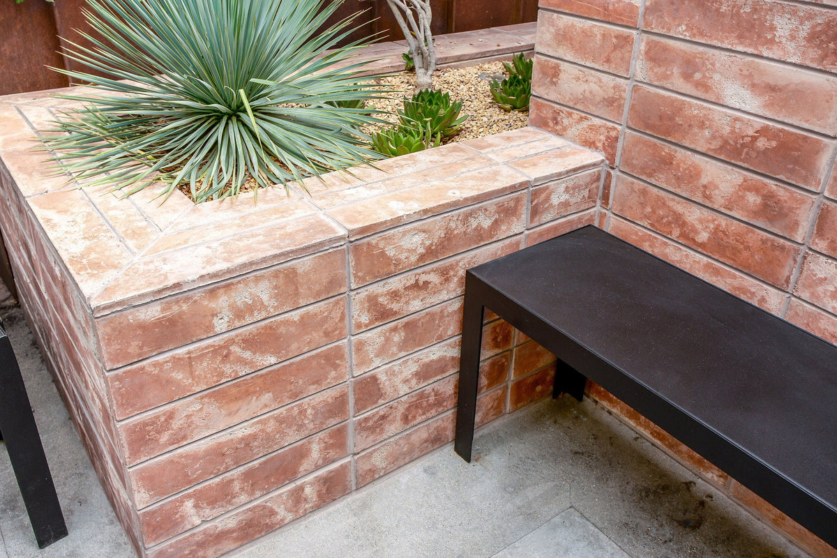 Tiled planter beside a bench