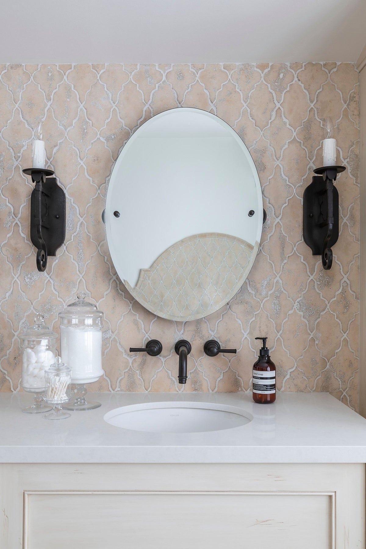 Oval mirror and iron sconces