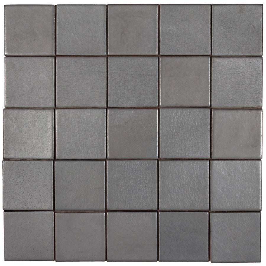 A field of Pewter tiles laid square, the satin surface holding the light evenly across each piece