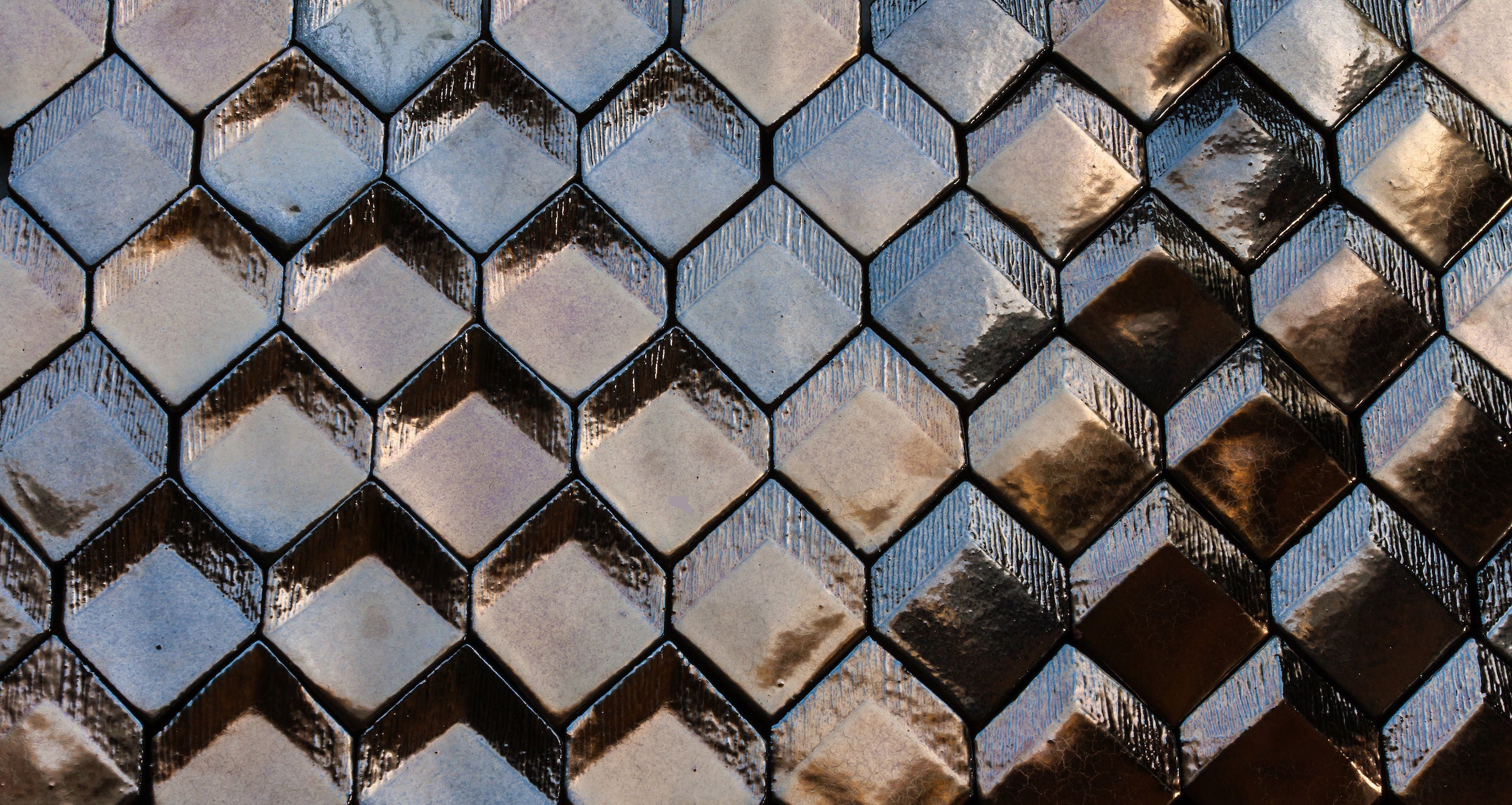 A wall of RR diamonds in metallic glaze, the flat, convex and concave faces each giving back a different amount of light