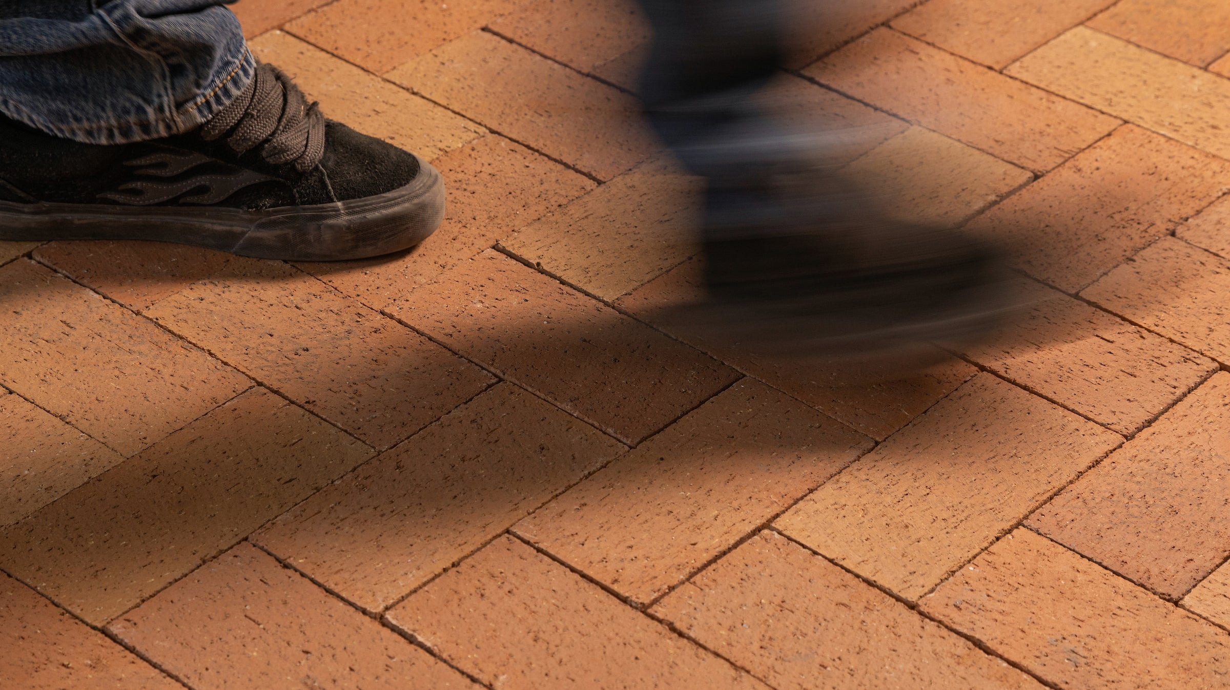 A floor of Catalina brick pavers in Saltillo with a person walking across it, one foot planted and one blurred in the stride