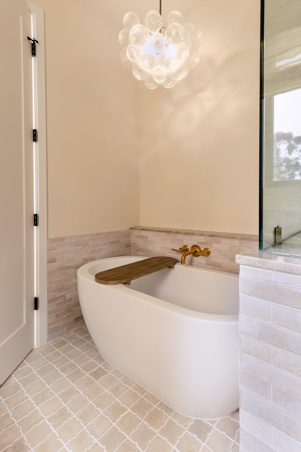 Tub below a glass chandelier